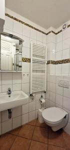 een witte badkamer met een wastafel en een toilet bij Sand-8 in Großenbrode