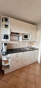 een keuken met witte kasten en een wastafel bij Sand-8 in Großenbrode