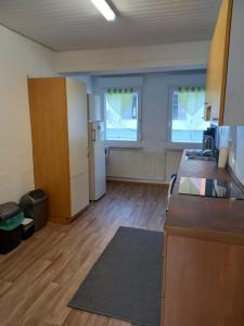 ein Büro mit einer Küche und ein Zimmer mit Holzböden in der Unterkunft Schöne Ferienwohnung in Gernsbach in Gernsbach