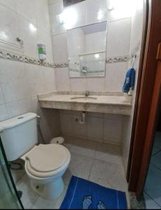 a bathroom with a toilet and a sink at Pousada paraiso das conchas hostel in Cabo Frio