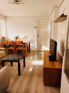a living room with a television and a dining room table at La casita de Soria in Soria