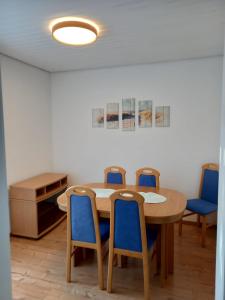 une chambre avec une table et quatre chaises bleues dans l'établissement Schöne Ferienwohnung in Gernsbach, à Gernsbach