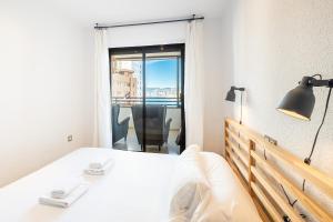 ein Schlafzimmer mit einem weißen Bett und einem Fenster in der Unterkunft Trinisol Apartment Sea Views 6E Levante Beach in Benidorm + 33 Fotos