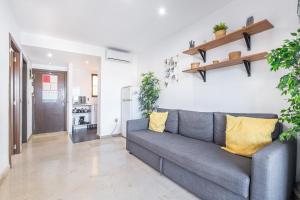ein Wohnzimmer mit einem grauen Sofa und einigen Pflanzen in der Unterkunft Trinisol Apartment Sea Views 6E Levante Beach in Benidorm