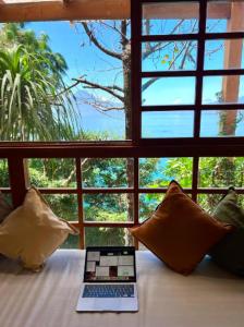 a laptop sitting on a bed in front of a window at Casa Catarina in Sololá