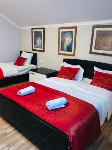 dwa łóżka w pokoju z czerwonym i białym w obiekcie Guest House Lulu w mieście Barisakho