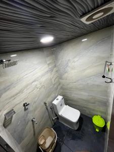 ein Badezimmer mit einem weißen WC und einem grünen Bidet in der Unterkunft Marhaba family dormitory in Kozhikode