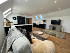 a living room with a couch and a table at The Hayloft in Sudbrooke