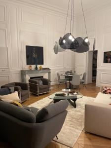 a living room with a couch and chairs and a table at Appartement Charles Le Brun, Face au Château de Versailles, avec parking privé en sous sol in Versailles