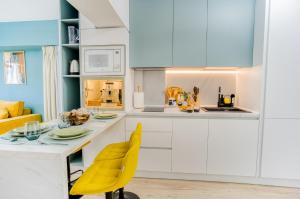 a kitchen with a table and yellow chairs at Hi-lux Ultracentral - 4BR Superior - Amazing View in Bucharest