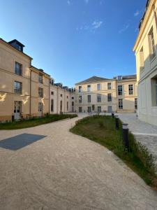 Appartement Charles Le Brun, Face au Château de Versailles, avec parking privé en sous sol في فرساي: صف من المباني مع طريق في الأمام