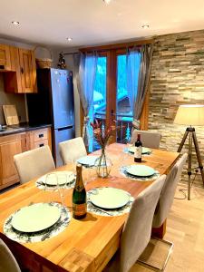 una mesa de madera con platos y copas de vino. en L'Eterlou, 2 minutes à pied des télécabines, Paradiski, Belle vue en Champagny-en-Vanoise