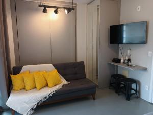 a living room with a couch with yellow pillows at Apartamentos Juliana Bela Vista in Sao Paulo