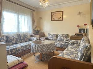 a living room with a couch and a table at Spacieux et familial à 2 minutes à pied du stade de football de RABAT in Rabat