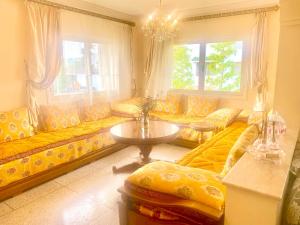 sala de estar con sofás amarillos y mesa en Spacieux et familial à 2 minutes à pied du stade de football de RABAT, en Rabat