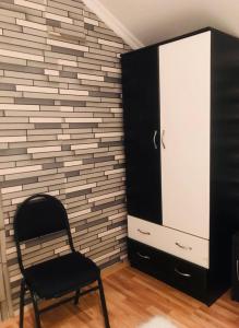 una sedia nera in una stanza con un muro di mattoni di Guest House Lulu a Barisakho