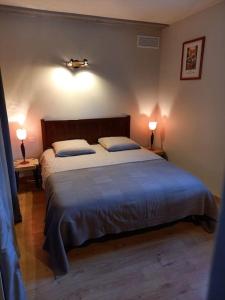 ein Schlafzimmer mit einem großen Bett mit zwei Lampen in der Unterkunft Au cœur du Vallon de Laghet, Maison Indépendante in La Trinité