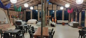 uma sala com mesas e cadeiras e um quarto em Risgua em Tinjacá
