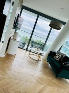 a living room with wood floors and large windows at Luxury Apartment Tyballtic 7th Floor in Międzyzdroje