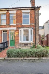 a brick house with a green door on a street at 42 Church Row - 2 beds and 2 bathrooms in Bury Saint Edmunds