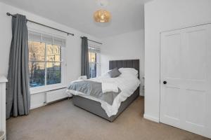 a white bedroom with a bed and a window at 42 Church Row - 2 beds and 2 bathrooms in Bury Saint Edmunds