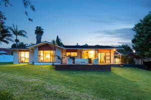 a house with a lawn in front of it at The waterfront 361-Family retreat with Netflix Skysport Air conditioner in each bedroom in Auckland