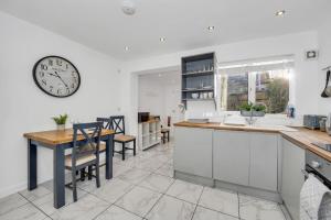 a kitchen with a table and a clock on the wall at 42 Church Row - 2 beds and 2 bathrooms in Bury Saint Edmunds