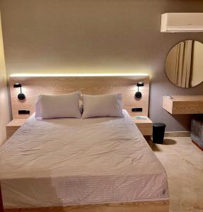 - une chambre avec un grand lit blanc et un miroir dans l'établissement Sun gate house, au Caire