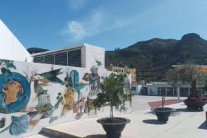 a mural on the side of a building with trees at Casa en Calle del Agua in Vega de San Mateo