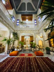 uma ampla sala de estar com almofadas laranja num tapete em RIAD LALLA ZINEB em Rabat