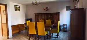 a dining room with a table and yellow chairs at Etablissement commun avec chambre privé tranquille avec jardin a 10 min a pied de la gare de Fleury-les-Aubrais et 2 min d Orléans in Fleury-les-Aubrais