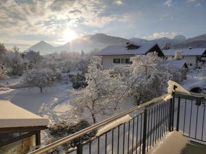 a balcony with snow covered trees and a house at Ferienwohnung Morgensonne in Bad Feilnbach