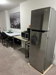 a kitchen with a refrigerator and a table with a microwave at Cozy, Spacious 2 bdrm basement apartment with kitchenette, sleeps up to 5 in Brampton