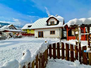 a house covered in snow next to a fence at Chalet Mama in Pruggern