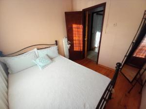 a bedroom with a white bed with a pillow on it at Andreas House in Valíra