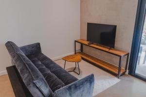 ein Wohnzimmer mit Sofa und Fernseher in der Unterkunft Peace Lofts and Apartments in Playa Santa Teresa