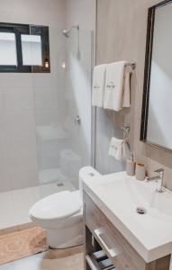 a bathroom with a toilet and a sink and a shower at Peace Lofts and Apartments in Santa Teresa Beach