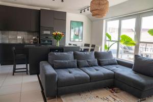 a living room with a couch and a kitchen at Taylor Apartman in Eger