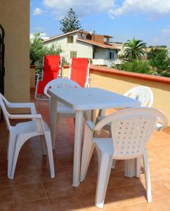 un tavolo bianco e sedie su un patio di Casa Floriana a San Leone a San Leone