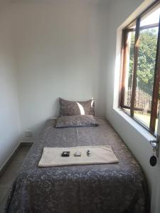 Un dormitorio con una cama y una bandeja. en Seabreeze Modern Apartment sleeps up to 4 people, en Durban