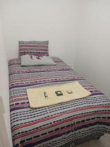 Una cama con un bolso encima. en Seabreeze Modern Apartment sleeps up to 4 people, en Durban