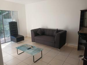 a living room with a couch and a coffee table at Seabreeze Modern Apartment sleeps up to 4 people in Durban