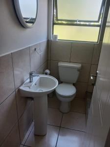 a bathroom with a toilet and a sink at Seabreeze Modern Apartment sleeps up to 4 people in Durban