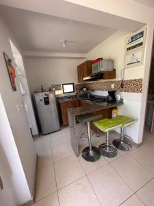 una piccola cucina con bancone e frigorifero di Apartamento 3 Piscinas Tobogán y Zonas Verdes Cerca al Parque del Café a La Tebaida