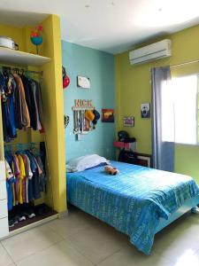 una camera con letto e armadio con vestiti di Depa de 3 dormitorios y parqueo a Guayaquil