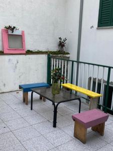 two benches and a table with a vase on it at A Casa da Rapariga de Cabelo Azul in Manteigas