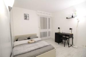 Habitación blanca con cama y escritorio en Bel appartement meublé 4 pièces, en Ris-Orangis