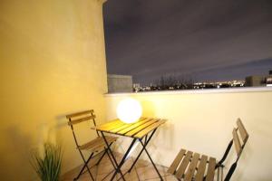 una mesa y 2 sillas en un balcón por la noche en Bel appartement meublé 4 pièces, en Ris-Orangis