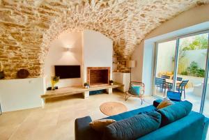 een woonkamer met een blauwe bank en een open haard bij Terra Nostra - Townhouse - Swimming pool in Nîmes