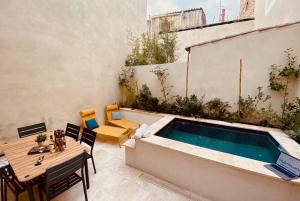 een patio met een tafel en een zwembad bij Terra Nostra - Townhouse - Swimming pool in Nîmes